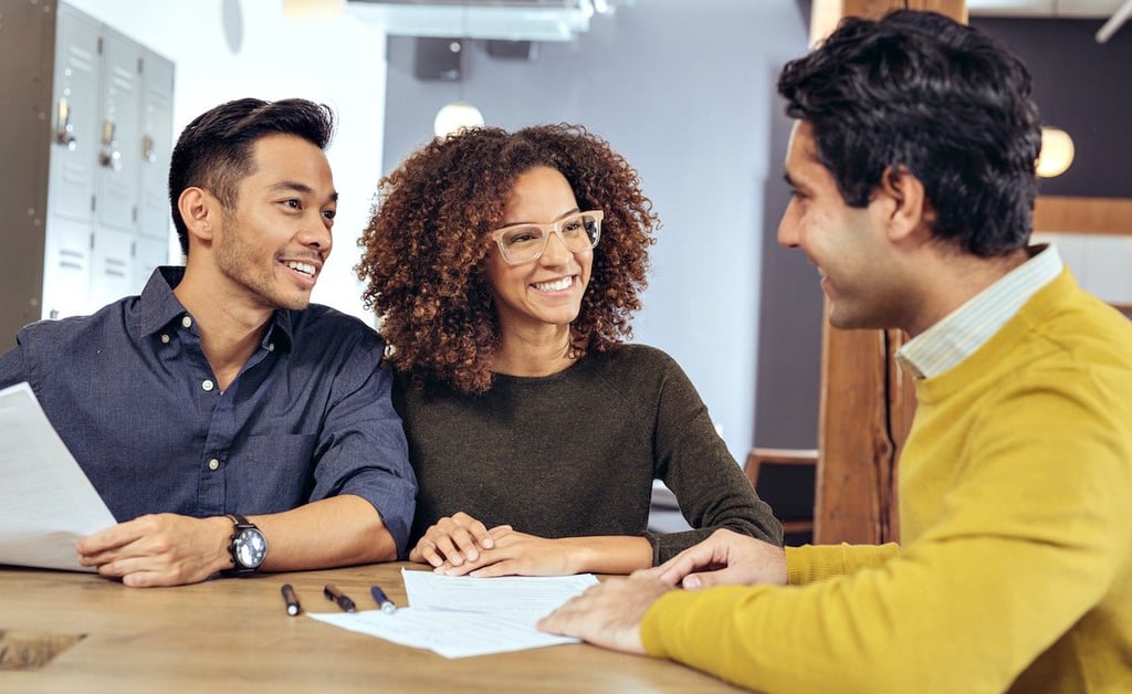 A couple reviews paperwork with a real estate professional