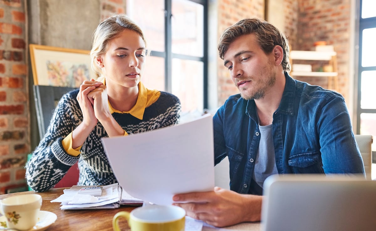 Young couple discussing over document at home