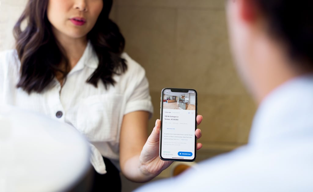 real estate agent handing keys to smiling buyers outside a home