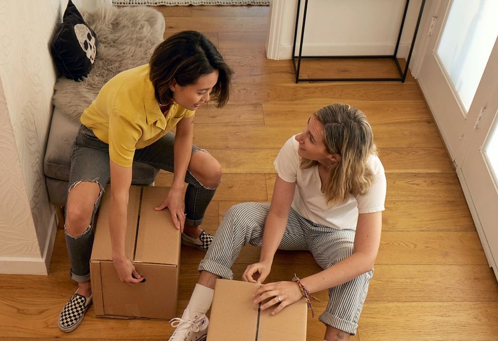 Two women packing boxes for a move