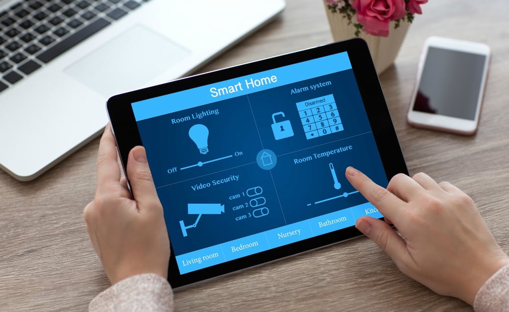 woman hands holding tablet PC computer with smart home near laptop and phone