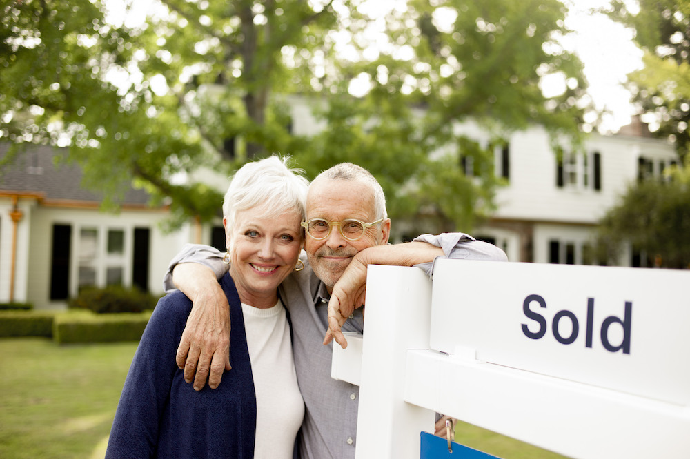 smiling-couple-with-sold-sign-image