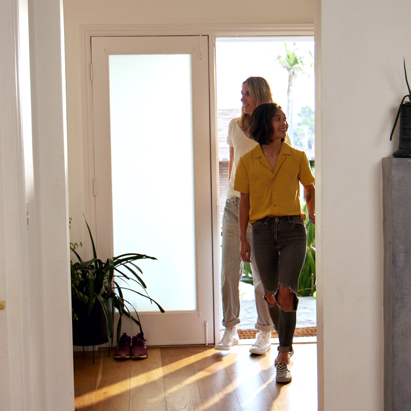 Buyer walking up to the front porch of a suburban home during a self-guided daytime tour