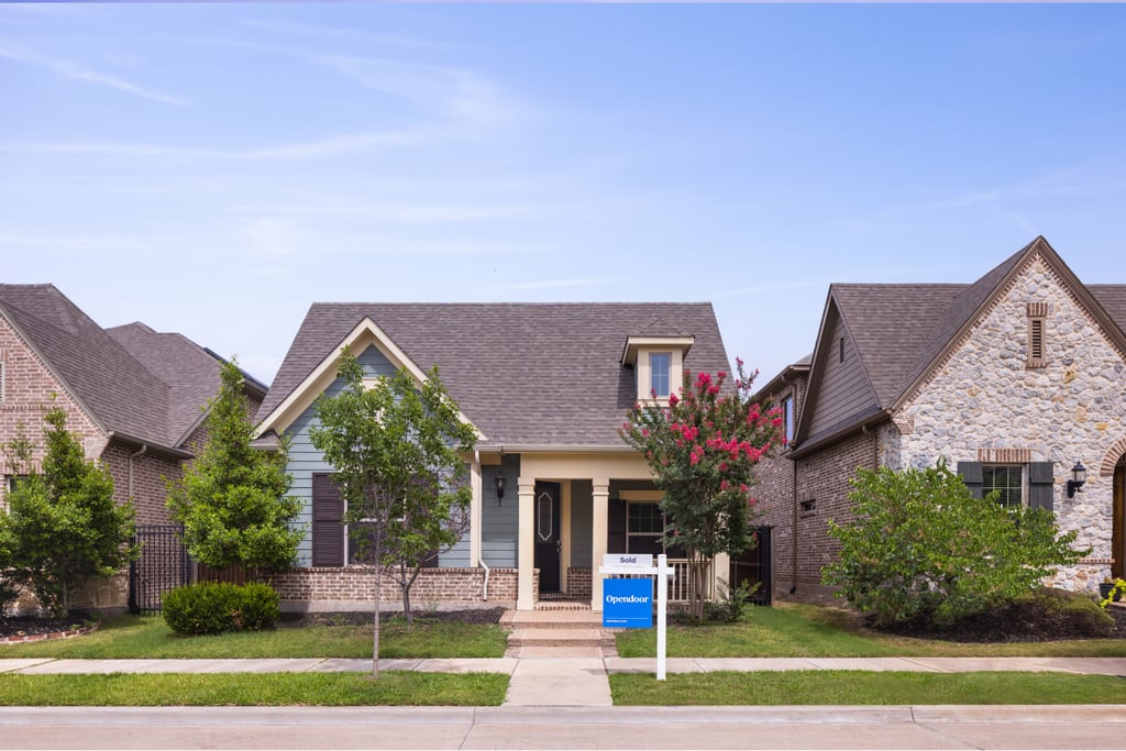 A modern single-family home with a manicured front lawn on a quiet residential street.