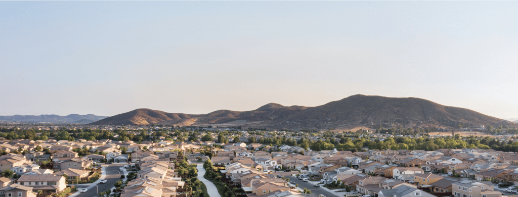 A wide-angle view of a suburban neighborhood with tree-lined streets and single-family homes