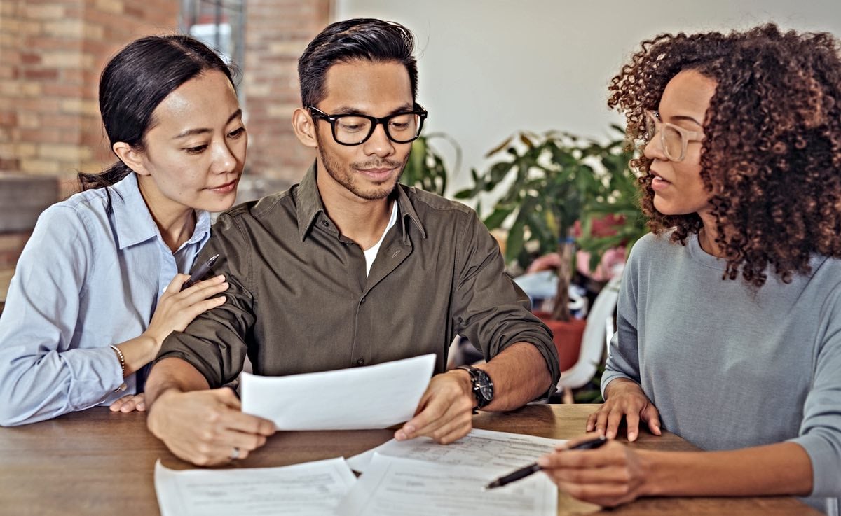 Two people sitting at a table reviewing paperwork during a negotiation