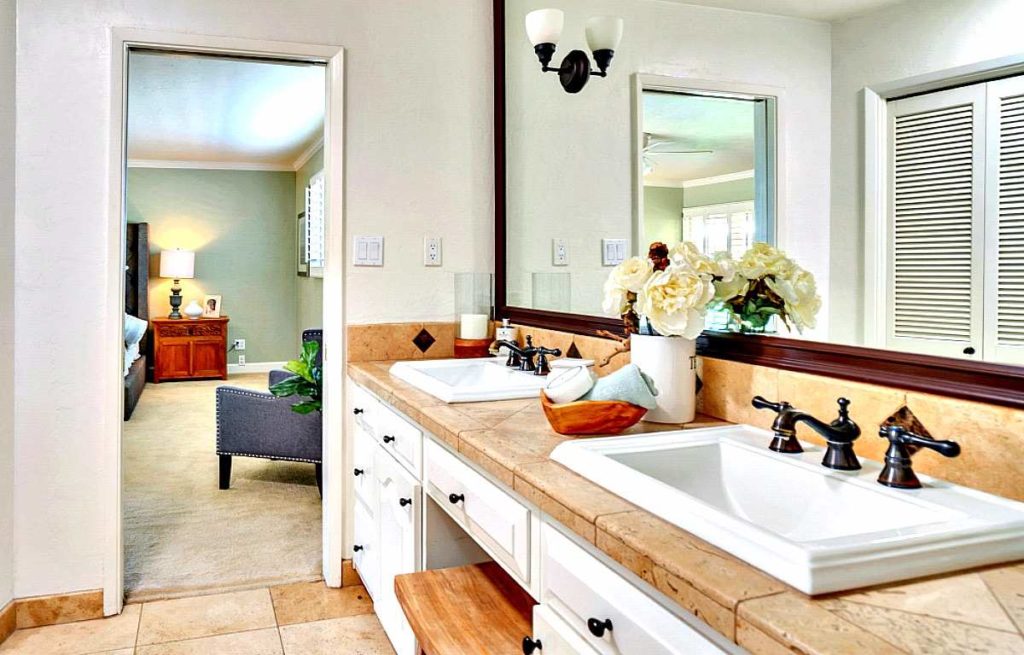 Modern residential bathroom with sink, mirror, and neutral tile finishes